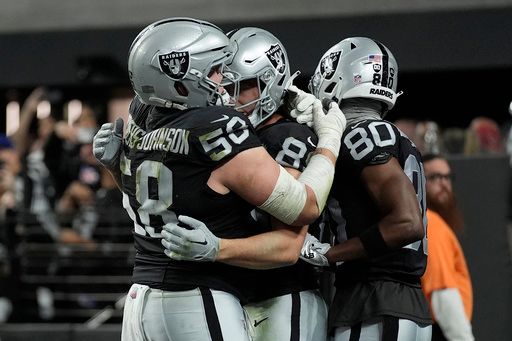 Las Vegas Raiders tight end Brock Bowers, middle, is congratulated by guard Jackson Powers-Johnson (58) and wide receiver Terrace Marshall Jr. (80) after scoring against the Los Angeles Chargers during the second half of an NFL football game in Las Vegas, Sunday, Jan. 5, 2025. (AP Photo/John Locher)