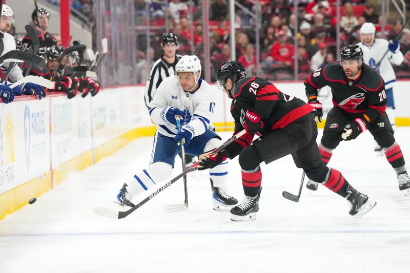 Dec 4, 2025; Raleigh, North Carolina, USA; Toronto Maple Leafs center Max Domi (11) and Carolina Hurricanes defenseman Sean Walker (26) battle over the puck during the second period at Lenovo Center. Mandatory Credit: James Guillory-Imagn Images Dec 4, 2025; Raleigh, North Carolina, USA; Toronto Maple Leafs center Max Domi (11) and Carolina Hurricanes defenseman Sean Walker (26) battle over the puck during the second period at Lenovo Center. Mandatory Credit: James Guillory-Imagn Images