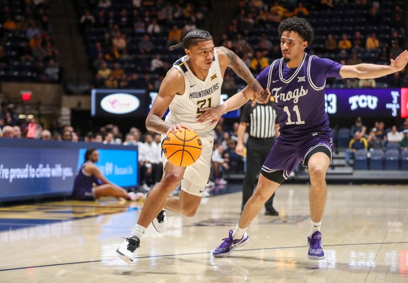 Mar 6, 2024; Morgantown, West Virginia, USA; West Virginia Mountaineers guard RaeQuan Battle (21) drives against TCU Horned Frogs guard Trevian Tennyson (11) during the second half at WVU Coliseum. Mandatory Credit: Ben Queen-USA TODAY Sports