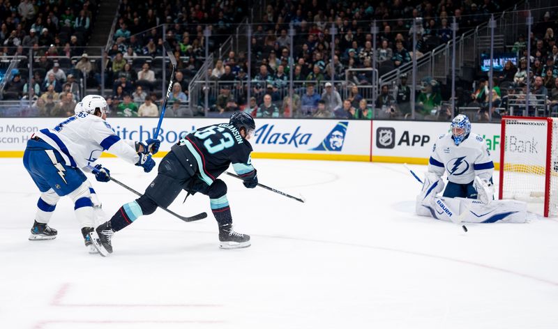 Mar 17, 2026; Seattle, Washington, USA; Seattle Kraken forward Jacob Melanson (63) takes a shot against Tampa Bay Lightning goalie Andrei Vasilevskiy (88) and defenseman Charle-Edouard D'Astous (51), left, during the second period at Climate Pledge Arena. Mandatory Credit: Stephen Brashear-Imagn Images