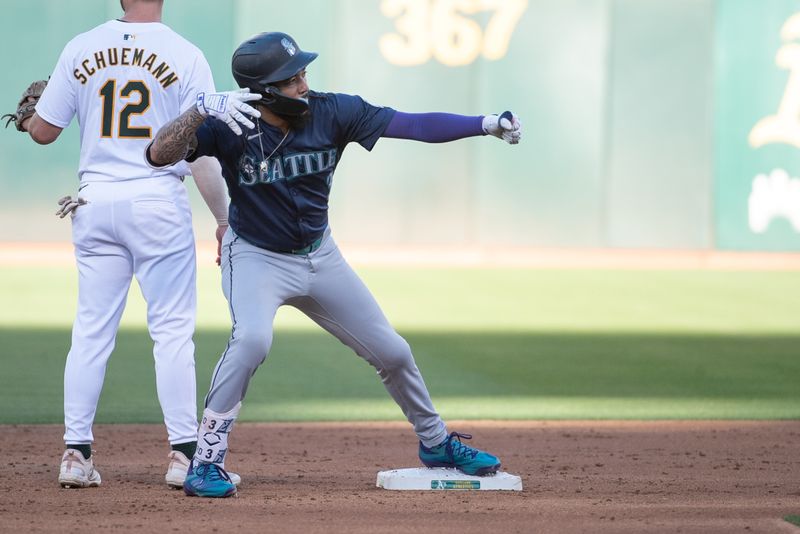 Jun 4, 2024; Oakland, California, USA; Seattle Mariners shortstop J.P. Crawford (3) motions to his team mates after hitting a double against the Oakland Athletics during the second inning at Oakland-Alameda County Coliseum. Mandatory Credit: Ed Szczepanski-USA TODAY Sports