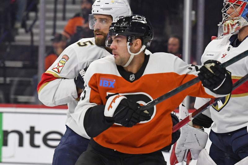 Dec 5, 2024; Philadelphia, Pennsylvania, USA; Philadelphia Flyers center Ryan Poehling (25) and Florida Panthers defenseman Aaron Ekblad (5) battle for position during the first period at Wells Fargo Center. Mandatory Credit: Eric Hartline-Imagn Images