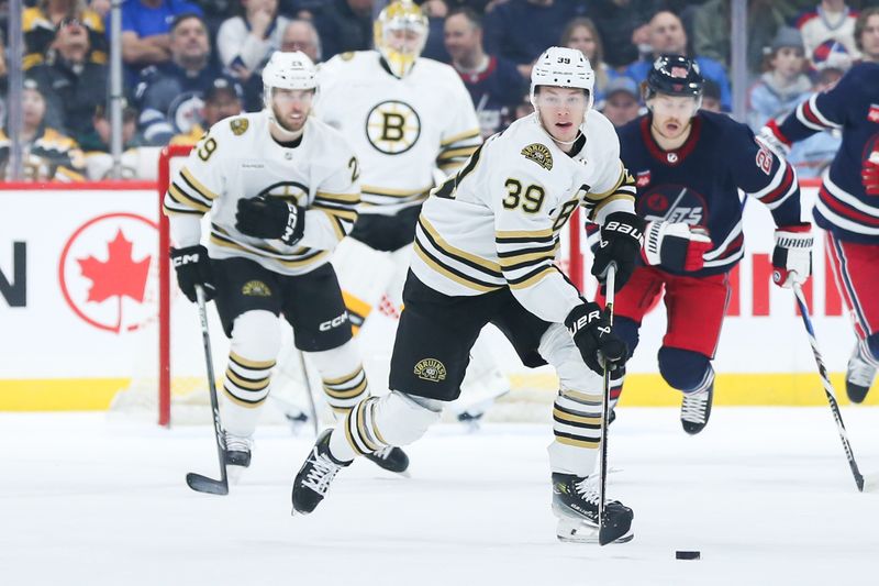 Dec 22, 2023; Winnipeg, Manitoba, CAN;  Boston Bruins forward Morgan Geekie (39) skates into the Winnipeg Jets zone during the first period at Canada Life Centre. Mandatory Credit: Terrence Lee-USA TODAY Sports