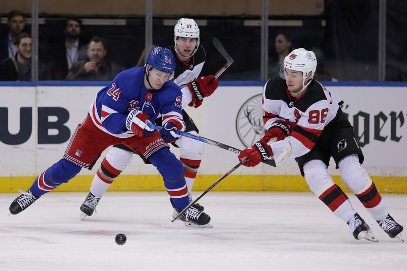 Mar 11, 2024; New York, New York, USA; New York Rangers right wing Kaapo Kakko (24) and New Jersey Devils center Jack Hughes (86) fight for the puck during the first period at Madison Square Garden. Mandatory Credit: Brad Penner-USA TODAY Sports