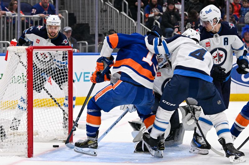 Mar 23, 2024; Elmont, New York, USA;  New York Islanders center Mathew Barzal (13) scores a goal past Winnipeg Jets goaltender Laurent Brossoit (39) during the second period at UBS Arena. Mandatory Credit: Dennis Schneidler-USA TODAY Sports