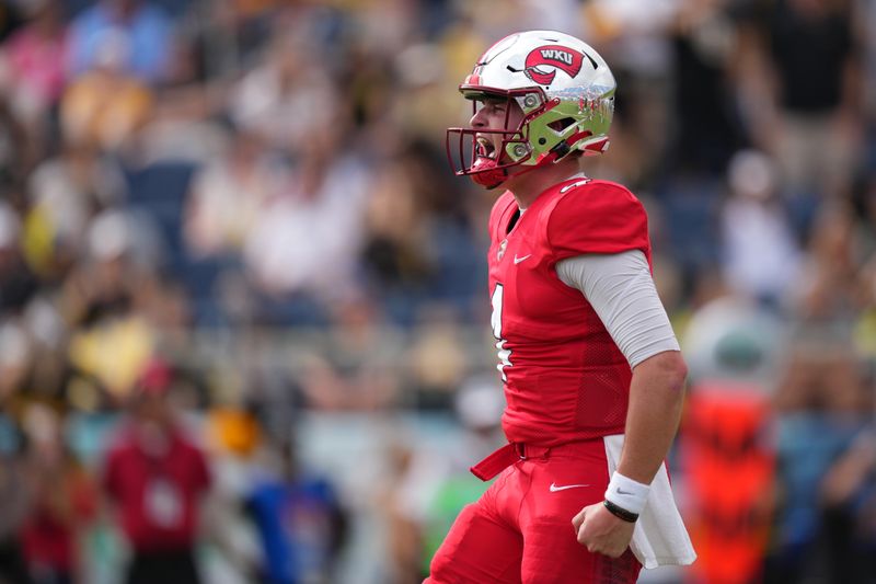 Dec 18, 2021; Boca Raton, Florida, USA; Western Kentucky Hilltoppers quarterback Bailey Zappe (4) celebrates after throwing a touchdown to break Joe Burrows single season touchdown passing record during the second half against the Appalachian State Mountaineers in the 2021 Boca Raton Bowl at FAU Stadium. Mandatory Credit: Jasen Vinlove-USA TODAY Sports