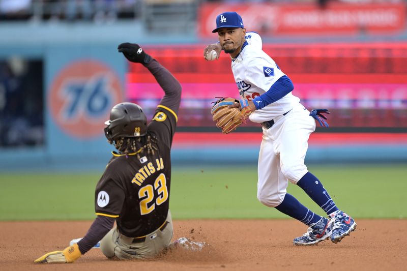 Apr 14, 2024; Los Angeles, California, USA; San Diego Padres outfielder Fernando Tatis Jr. (23) is out at second as Los Angeles Dodgers shortstop Mookie Betts (50) throws to first to complete a double play in the fifth inning at Dodger Stadium. Mandatory Credit: Jayne Kamin-Oncea-USA TODAY Sports