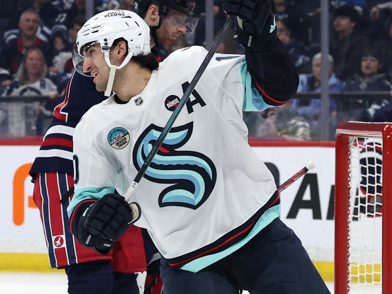 Jan 16, 2025; Winnipeg, Manitoba, CAN; Seattle Kraken center Matty Beniers (10) celebrates his goal against the Winnipeg Jets during the first period at Canada Life Centre. Mandatory Credit: James Carey Lauder-Imagn Images