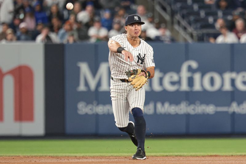 Apr 9, 2024; Bronx, New York, USA; New York Yankees shortstop Anthony Volpe (11) throws the ball to first base for an out during the fourth inning against the New York Yankees at Yankee Stadium. Mandatory Credit: Vincent Carchietta-USA TODAY Sports