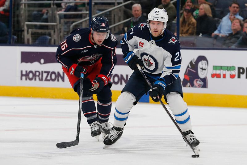 Mar 17, 2024; Columbus, Ohio, USA; Winnipeg Jets left wing Nikolaj Ehlers (27) carries the puck as Columbus Blue Jackets center Brendan Gaunce (16) trails the play during the first period at Nationwide Arena. Mandatory Credit: Russell LaBounty-USA TODAY Sports