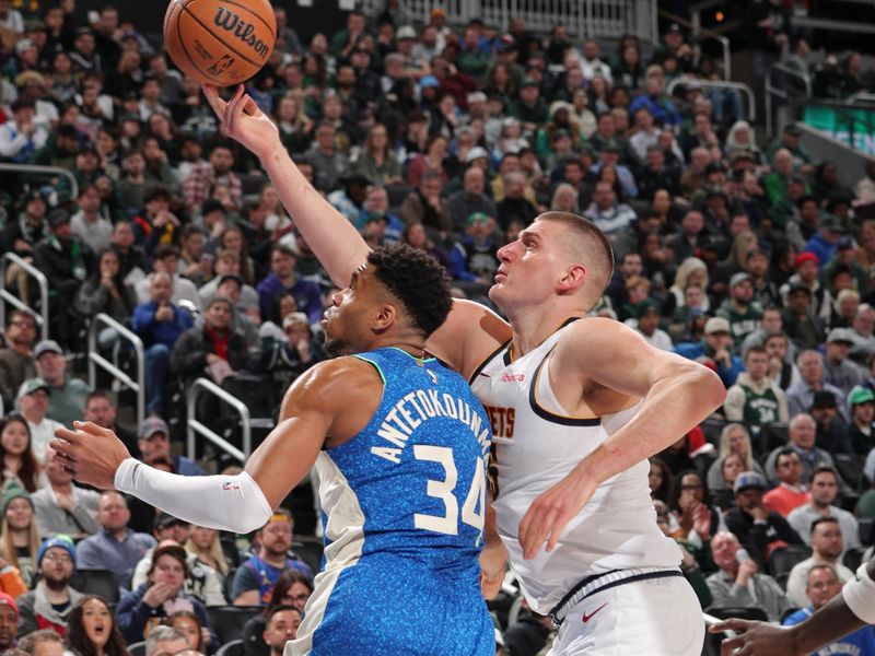 MILWAUKEE, WI - FEBRUARY 12: Nikola Jokic #15 of the Denver Nuggets grabs loose ball during the game against the Milwaukee Bucks on February 12, 2024 at the Fiserv Forum Center in Milwaukee, Wisconsin. NOTE TO USER: User expressly acknowledges and agrees that, by downloading and or using this Photograph, user is consenting to the terms and conditions of the Getty Images License Agreement. Mandatory Copyright Notice: Copyright 2024 NBAE (Photo by Gary Dineen/NBAE via Getty Images).