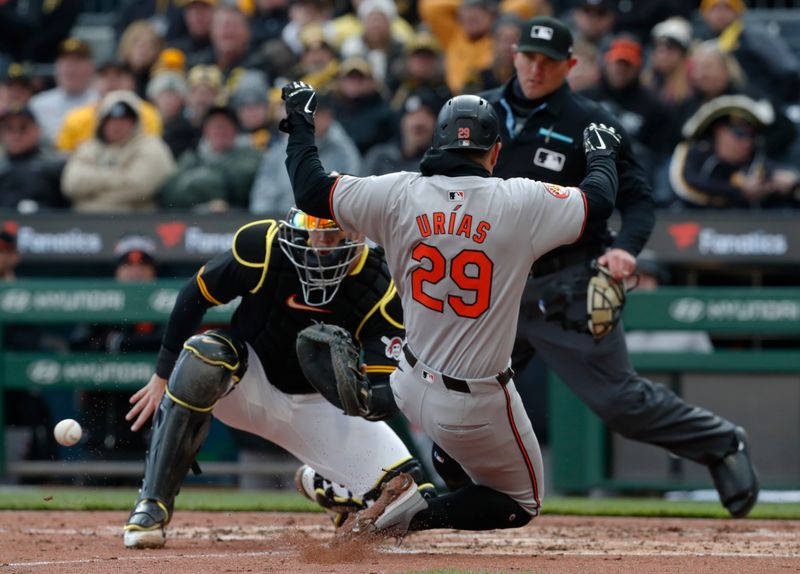 Apr 5, 2024; Pittsburgh, Pennsylvania, USA;  Baltimore Orioles third base Ramón Urías (29) slides home to score a run against Pittsburgh Pirates catcher Henry Davis (32) during the seventh inning at PNC Park. Mandatory Credit: Charles LeClaire-USA TODAY Sports