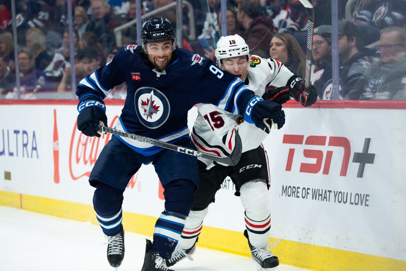 Jan 11, 2024; Winnipeg, Manitoba, CAN; Winnipeg Jets forward Alex Iafallo (9) and Chicago Blackhawks forward Joey Anderson (15) skate for the puck during the first period at Canada Life Centre. Mandatory Credit: Terrence Lee-USA TODAY Sports