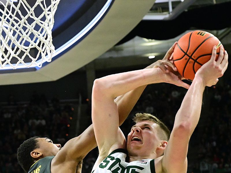 Feb 20, 2024; East Lansing, Michigan, USA;  Iowa Hawkeyes guard Tony Perkins (11) fouls Michigan State Spartans forward Jaxon Kohler (0) during the second half at Jack Breslin Student Events Center. Mandatory Credit: Dale Young-USA TODAY Sports
