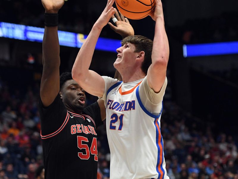 Mar 14, 2024; Nashville, TN, USA; Florida Gators forward Alex Condon (21) shoots against Georgia Bulldogs center Russel Tchewa (54) during the first half at Bridgestone Arena. Mandatory Credit: Christopher Hanewinckel-USA TODAY Sports