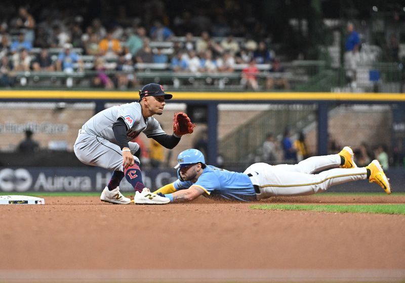 Aug 16, 2024; Milwaukee, Wisconsin, USA; Milwaukee Brewers outfielder Garrett Mitchell (5) slides in safely ahead of the tag by Cleveland Guardians second base Andrés Giménez (0) in the eighth inning at American Family Field. Mandatory Credit: Michael McLoone-USA TODAY Sports