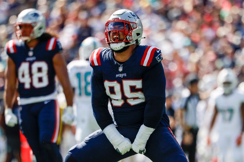 New England Patriots defensive tackle Daniel Ekuale (95) reacts after a stop during the first half of an NFL football game against the Miami Dolphins on Sunday, Oct. 6, 2024, in Foxborough, Mass. (AP Photo/Greg M. Cooper)