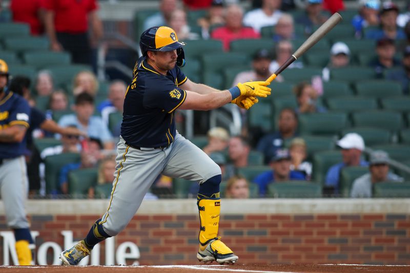 Aug 7, 2024; Atlanta, Georgia, USA; Milwaukee Brewers first baseman Rhys Hoskins (12) hits a single against the Atlanta Braves in the first inning at Truist Park. Mandatory Credit: Brett Davis-USA TODAY Sports