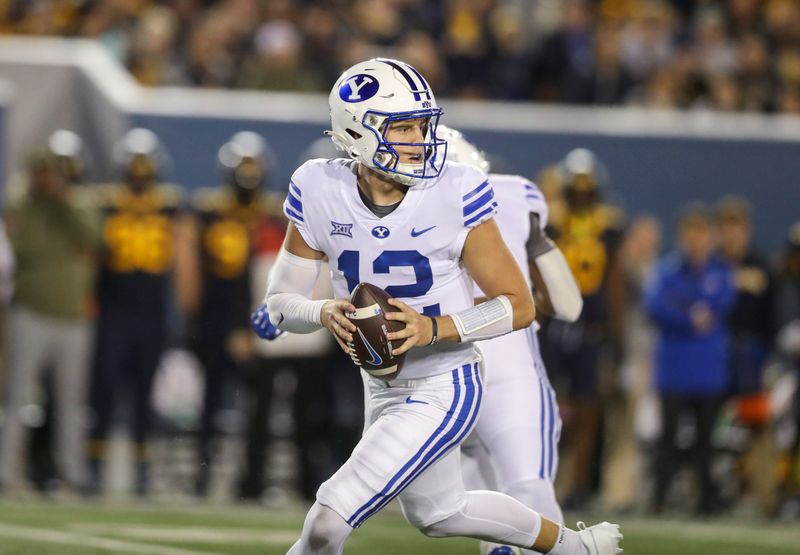 Nov 4, 2023; Morgantown, West Virginia, USA; Brigham Young Cougars quarterback Jake Retzlaff (12) drops back for a pass during the second quarter against the West Virginia Mountaineers at Mountaineer Field at Milan Puskar Stadium. Mandatory Credit: Ben Queen-USA TODAY Sports