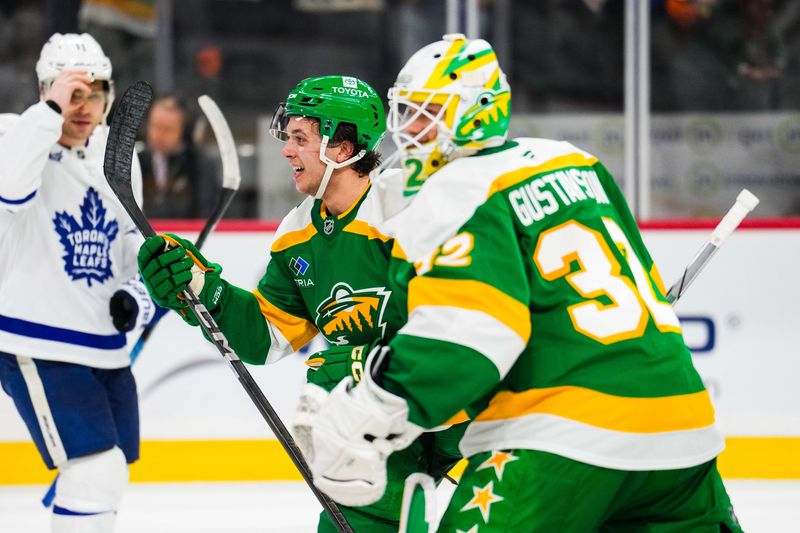 Nov 3, 2024; Saint Paul, Minnesota, USA; Minnesota Wild defenseman Brock Faber (7) celebrates with goaltender Filip Gustavsson (32) following the game against the Toronto Maple Leafs at Xcel Energy Center. Mandatory Credit: Brace Hemmelgarn-Imagn Images