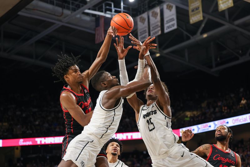 Jan 25, 2023; Orlando, Florida, USA; UCF Knights forward Taylor Hendricks (25) forward Lahat Thioune (0) and Houston Cougars guard Tramon Mark (12) battle for the rebound during the second half at Addition Financial Arena. Mandatory Credit: Mike Watters-USA TODAY Sports