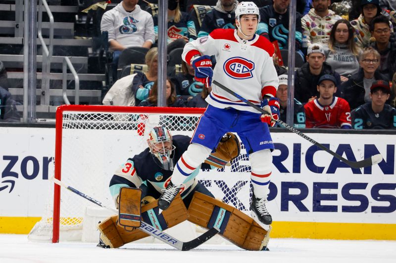 Mar 24, 2024; Seattle, Washington, USA; Montreal Canadiens left wing Juraj Slafkovsky (20) jumps in anticipation of a possible shot against Seattle Kraken goaltender Philipp Grubauer (31) during the first period at Climate Pledge Arena. Mandatory Credit: Joe Nicholson-USA TODAY Sports