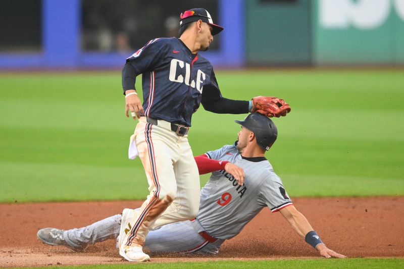 Sep 18, 2024; Cleveland, Ohio, USA; Minnesota Twins designated hitter Trevor Larnach (9) is tagged out by Cleveland Guardians second baseman Andres Gimenez (0) while attempting to steal second base in the first inning at Progressive Field. Mandatory Credit: David Richard-Imagn Images