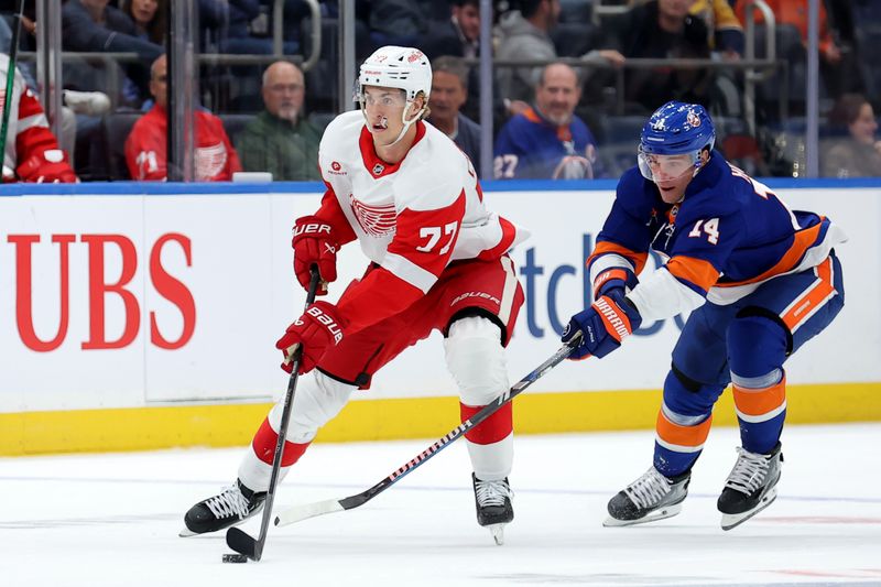 Oct 22, 2024; Elmont, New York, USA; Detroit Red Wings defenseman Simon Edvinsson (77) skates with the puck against New York Islanders center Bo Horvat (14) during the first period at UBS Arena. Mandatory Credit: Brad Penner-Imagn Images