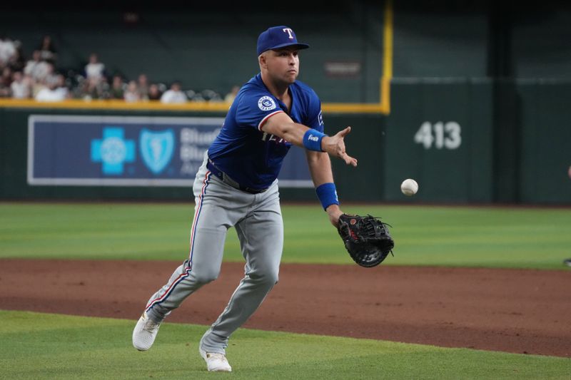 Sep 10, 2024; Phoenix, Arizona, USA; Texas Rangers first base Nathaniel Lowe (30) flips the ball for an out against the Arizona Diamondbacks in the eighth inning at Chase Field. Mandatory Credit: Rick Scuteri-Imagn Images