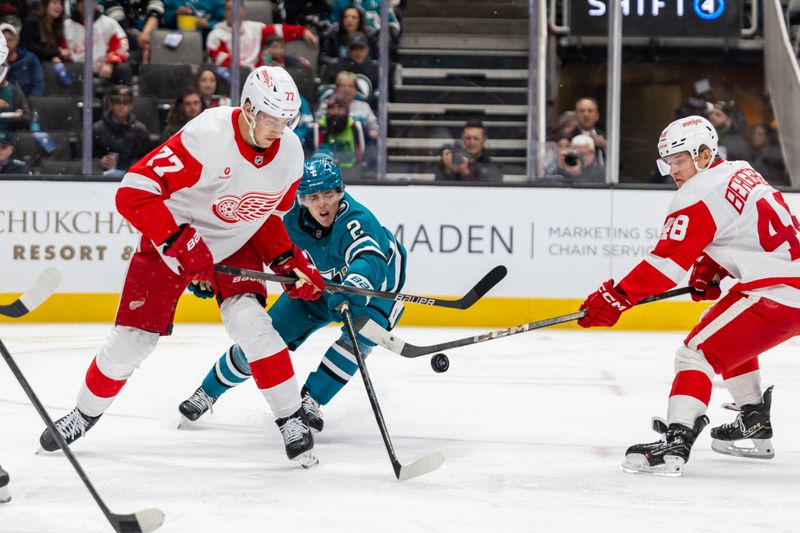 Nov 18, 2024; San Jose, California, USA; Detroit Red Wings defenseman Simon Edvinsson (77) and San Jose Sharks center Will Smith (2) fight for the puck during the second period at SAP Center at San Jose. Mandatory Credit: Bob Kupbens-Imagn Images