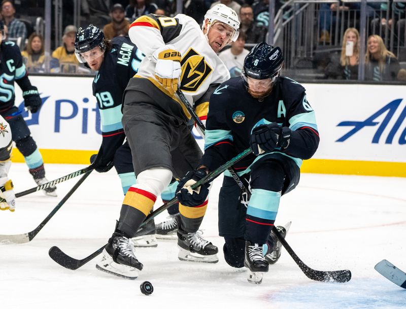 Nov 8, 2024; Seattle, Washington, USA;  Seattle Kraken defenseman Adam Larsson (6), right, and Vegas Golden Knights forward Tanner Pearson (70) battle for the puck during the third period at Climate Pledge Arena. Mandatory Credit: Stephen Brashear-Imagn Images