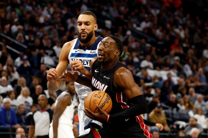 MINNEAPOLIS, MINNESOTA - OCTOBER 28: Bam Adebayo #13 of the Miami Heat drives to the basket while Rudy Gobert #27 of the Minnesota Timberwolves defends in the second quarter at Target Center on October 28, 2023 in Minneapolis, Minnesota. NOTE TO USER: User expressly acknowledges and agrees that, by downloading and or using this photograph, User is consenting to the terms and conditions of the Getty Images License Agreement. (Photo by David Berding/Getty Images)