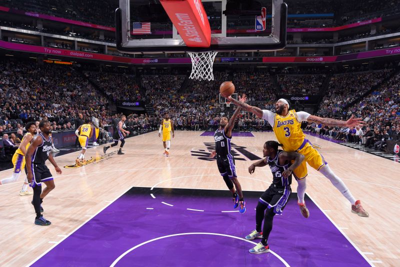 SACRAMENTO, CA - MARCH 13:  Anthony Davis #3 of the Los Angeles Lakers reaches for the ball over Davion Mitchell #15 of the Sacramento Kings on March 13, 2024 at Golden 1 Center in Sacramento, California. NOTE TO USER: User expressly acknowledges and agrees that, by downloading and or using this Photograph, user is consenting to the terms and conditions of the Getty Images License Agreement. Mandatory Copyright Notice: Copyright 2024 NBAE (Photo by Rocky Widner/NBAE via Getty Images)