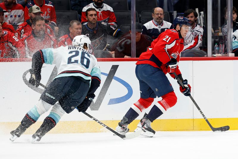Oct 21, 2025; Washington, District of Columbia, USA; Washington Capitals center Aliaksei Protas (21) skates with the puck as Seattle Kraken center Ryan Winterton (26) during the first period at Capital One Arena. Mandatory Credit: Geoff Burke-Imagn Images