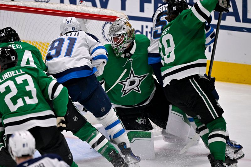 May 17, 2025; Dallas, Texas, USA; Winnipeg Jets center Cole Perfetti (91) and center Mark Scheifele (55) crash into Dallas Stars goaltender Jake Oettinger (29) during the third period in game six of the second round of the 2025 Stanley Cup Playoffs at American Airlines Center. Mandatory Credit: Jerome Miron-Imagn Images