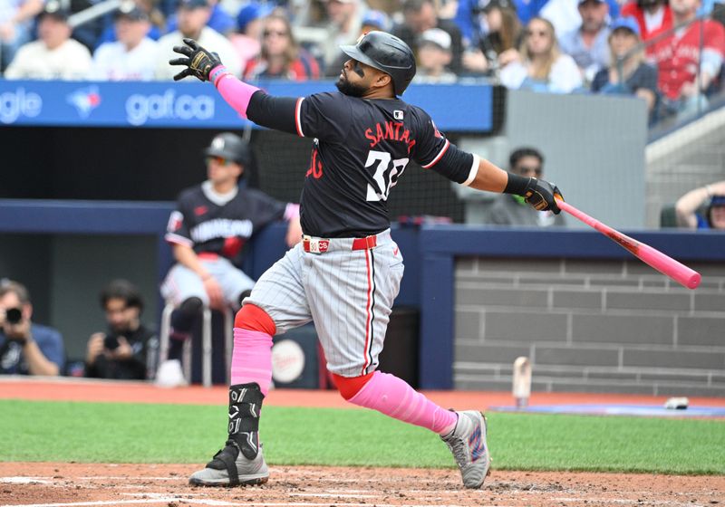 May 12, 2024; Toronto, Ontario, CAN;  Minnesota Twins first baseman Carlos Santana (30) hits a three run home run against the Toronto Blue Jays in the seventh inning at Rogers Centre. Mandatory Credit: Dan Hamilton-USA TODAY Sports