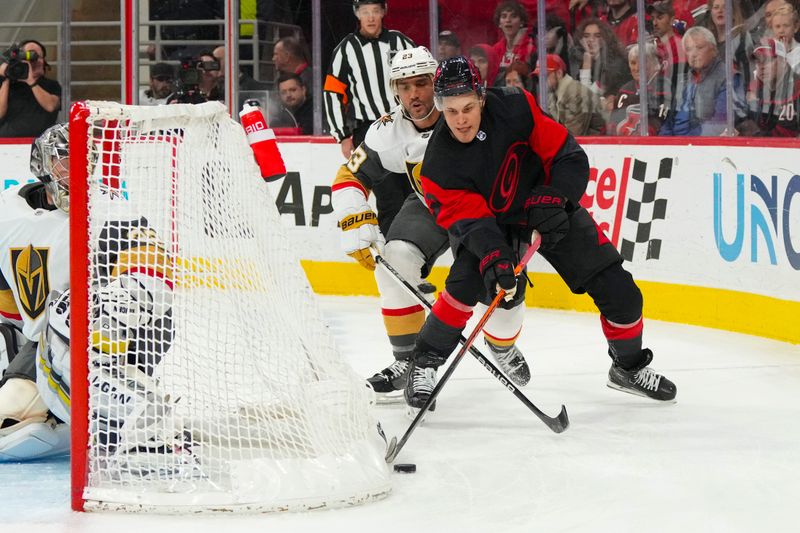 Mar 11, 2023; Raleigh, North Carolina, USA;  Carolina Hurricanes right wing Jesse Puljujarvi (13) skates with the puck past Vegas Golden Knights defenseman Alec Martinez (23) during the first period at PNC Arena. Mandatory Credit: James Guillory-USA TODAY Sports