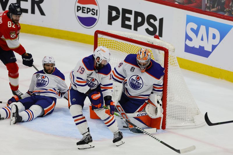 Jun 8, 2024; Sunrise, Florida, USA; Edmonton Oilers forward Adam Henrique (19) ad goaltender Skinner Stuart (74) defend against a shot on net by the Florida Panthers during the second period in game one of the 2024 Stanley Cup Final at Amerant Bank Arena. Mandatory Credit: Sam Navarro-USA TODAY Sports