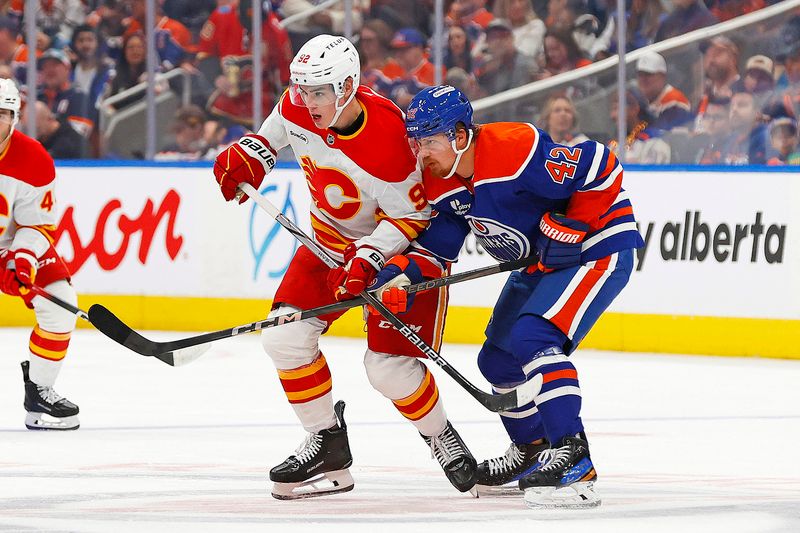 Oct 8, 2025; Edmonton, Alberta, CAN; Calgary Flames defensemen Maceo Phillips (92) and Edmonton Oilers forward Kasperi Kapanen (42) battle for position during the second period at Rogers Place. Mandatory Credit: Perry Nelson-Imagn Images