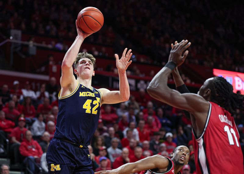 Feb 29, 2024; Piscataway, New Jersey, USA; Michigan Wolverines forward Will Tschetter (42) shoots as Rutgers Scarlet Knights forward Aundre Hyatt (5) and center Clifford Omoruyi (11) defend during the first half at Jersey Mike's Arena. Mandatory Credit: Vincent Carchietta-USA TODAY Sports