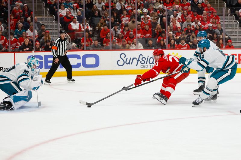 Jan 16, 2026; Detroit, Michigan, USA; Detroit Red Wings defenseman Albert Johansson (20) is defended by San Jose Sharks defensemen Sam Dickinson (6) and Nick Leddy (4) as he takes a shot on goaltender Yaroslav Askarov (30) during the second period at Little Caesars Arena. Mandatory Credit: Brian Bradshaw Sevald-Imagn Images