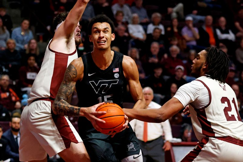 Jan 23, 2024; Blacksburg, Virginia, USA; Virginia Tech Hokies center Lynn Kidd (15) drives to the basket against Boston College Eagles forward Devin McGlockton (21) and forward Quinten Post (12) during the second half at Cassell Coliseum. Mandatory Credit: Peter Casey-USA TODAY Sports