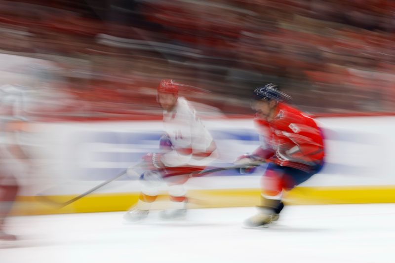 May 6, 2025; Washington, District of Columbia, USA; Carolina Hurricanes defenseman Jaccob Slavin (74) and Washington Capitals left wing Alex Ovechkin (8) chase the puck in the third period in game one of the second round of the 2025 Stanley Cup Playoffs at Capital One Arena. Mandatory Credit: Geoff Burke-Imagn Images