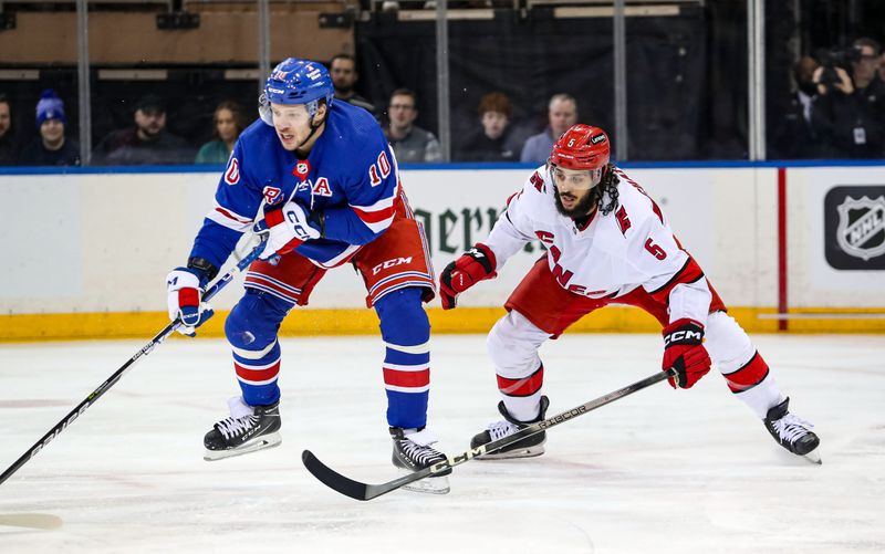 Jan 2, 2024; New York, New York, USA; New York Rangers left wing Artemi Panarin (10) and Carolina Hurricanes defenseman Jalen Chatfield (5) battle for the puck during the first period at Madison Square Garden. Mandatory Credit: Danny Wild-USA TODAY Sports