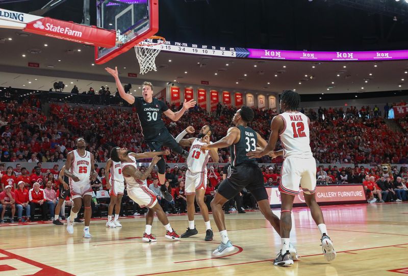 Jan 28, 2023; Houston, Texas, USA; Cincinnati Bearcats forward Viktor Lakhin (30) makes a basket against Houston Cougars guard Jamal Shead (1) in the second half at Fertitta Center. Houston Cougars won 75 to 69 .Mandatory Credit: Thomas Shea-USA TODAY Sports