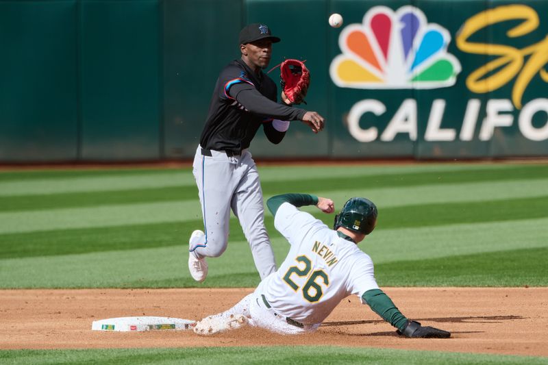 May 4, 2024; Oakland, California, USA; Miami Marlins infielder Tim Anderson (7) turns a double play against Oakland Athletics outfielder Tyler Nevin (26) during the first inning at Oakland-Alameda County Coliseum. Mandatory Credit: Robert Edwards-USA TODAY Sports