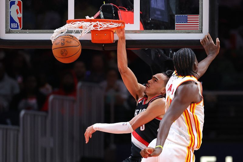 ATLANTA, GEORGIA - MARCH 27:  Dalano Banton #5 of the Portland Trail Blazers dunks against Clint Capela #15 of the Atlanta Hawks during the fourth quarter at State Farm Arena on March 27, 2024 in Atlanta, Georgia.  NOTE TO USER: User expressly acknowledges and agrees that, by downloading and/or using this photograph, user is consenting to the terms and conditions of the Getty Images License Agreement.  (Photo by Kevin C. Cox/Getty Images)