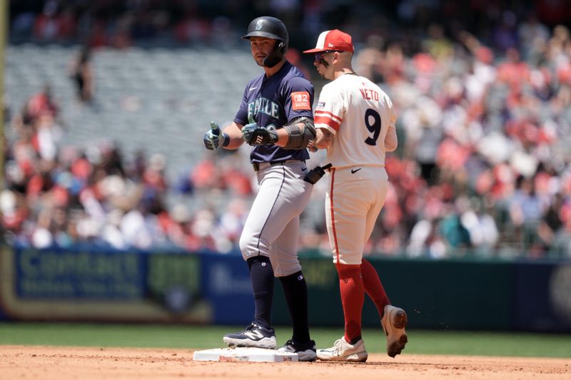 Jun 8, 2025; Anaheim, California, USA; Seattle Mariners third baseman Ben Williamson (9) reacts after hitting a double in the fourth inning as Los Angeles Angels shortstop Zach Neto (9) watches at Angel Stadium. Mandatory Credit: Kirby Lee-Imagn Images