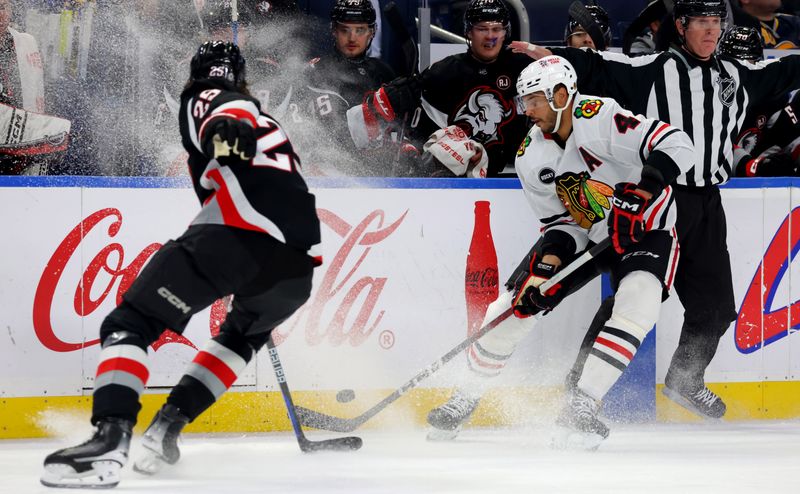 Jan 18, 2024; Buffalo, New York, USA;  Chicago Blackhawks defenseman Seth Jones (4) looks to control the puck as Buffalo Sabres defenseman Owen Power (25) defends during the third period at KeyBank Center. Mandatory Credit: Timothy T. Ludwig-USA TODAY Sports