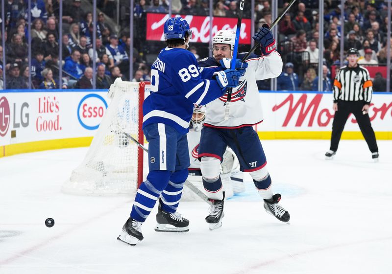 Nov 20, 2025; Toronto, Ontario, CAN; Toronto Maple Leafs left wing Nicholas Robertson (89) battles with Columbus Blue Jackets defenseman Denton Mateychuk (5) during the third period at Scotiabank Arena. Mandatory Credit: Nick Turchiaro-Imagn Images